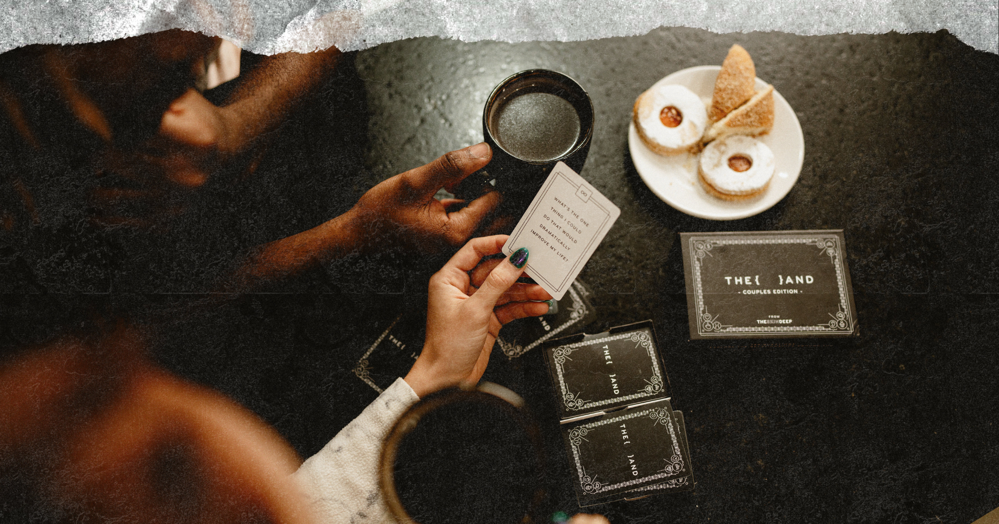 Picture of a couple in the kitchen drinking coffee, eating cookies playing a card game
