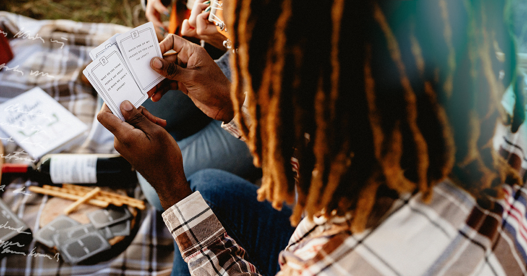 Picture of a couple playing a card game at a picnic date