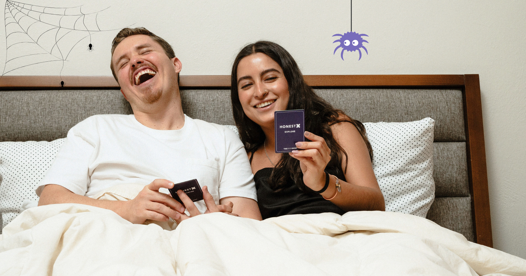 Picture of a laying in bed, laughing, and playing Honest X intimacy card game