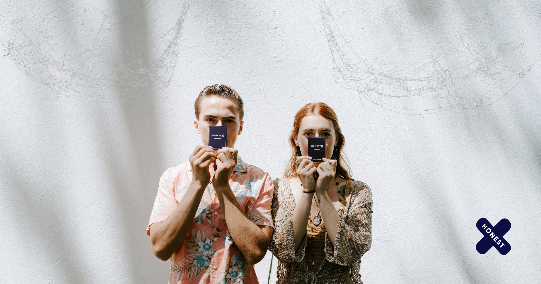 Picture of a couple holding Honest X cards over their mouths
