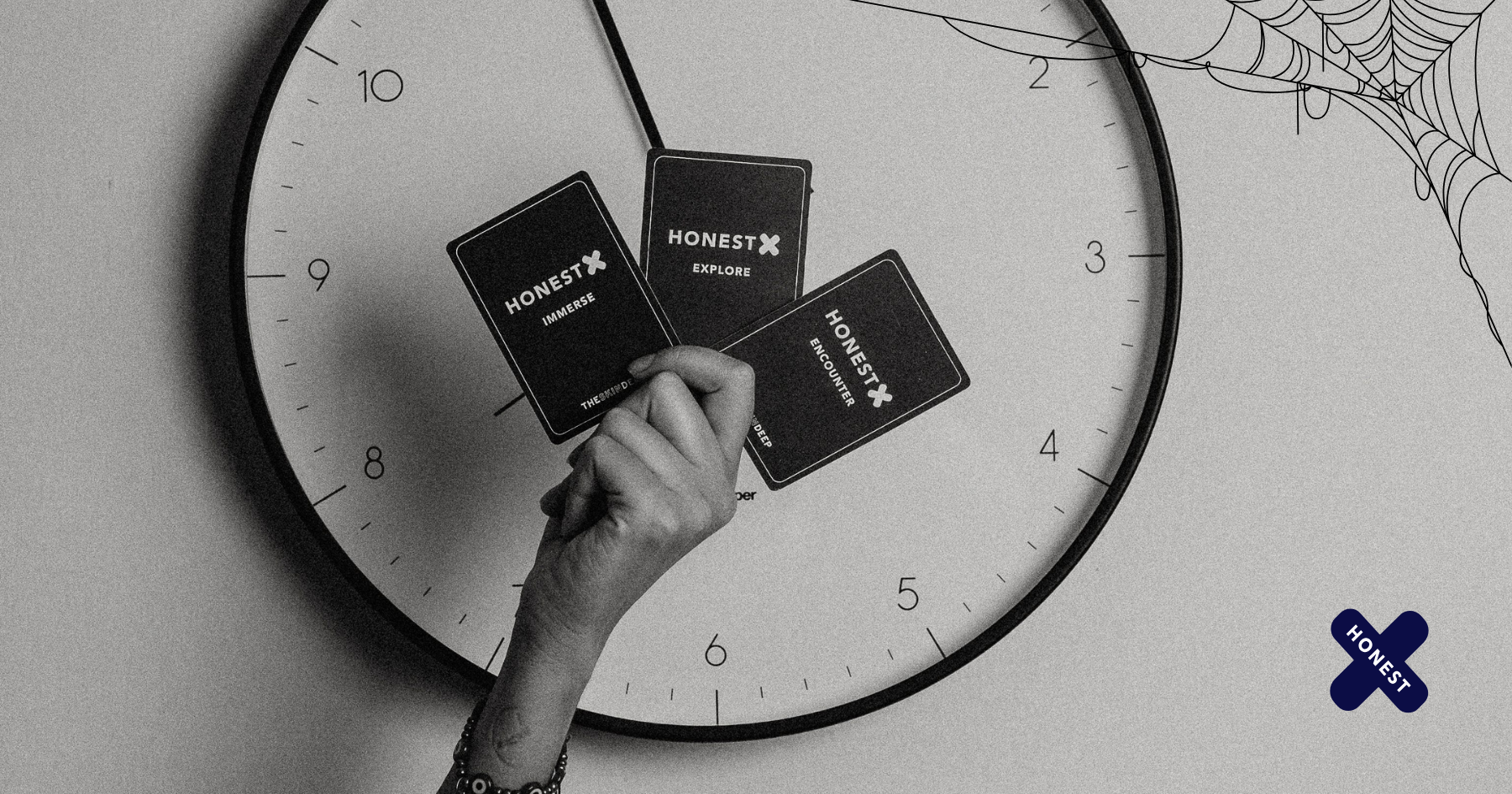 Picture of a hand over a clock holding 3 Honest X cards