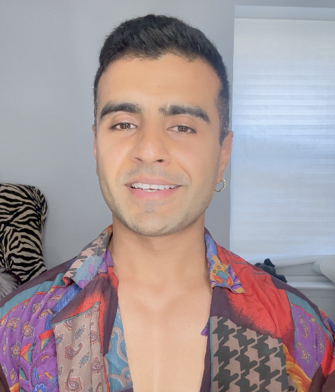 Man with an earring and a colorful shirt giving an interview