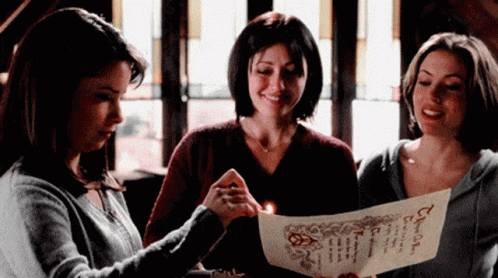 GIF from Charmed showing Piper, Prue and Phoebe lighting a piece of paper on fire