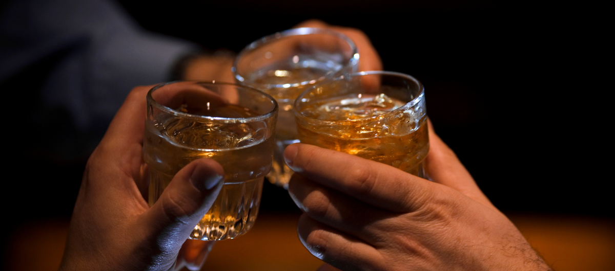 Three people having a toast at the end of the night with glasses touching together