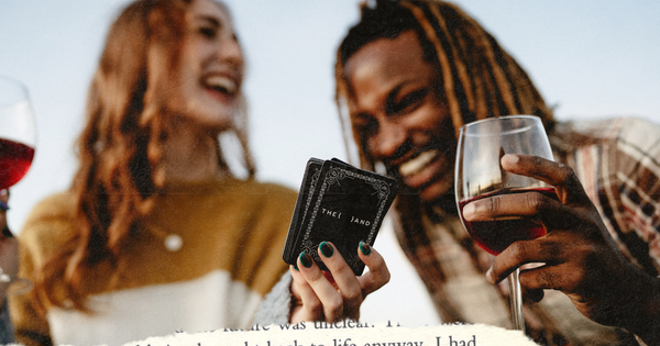 Picture of a couple drinking red wine and playing a card game while laughing together